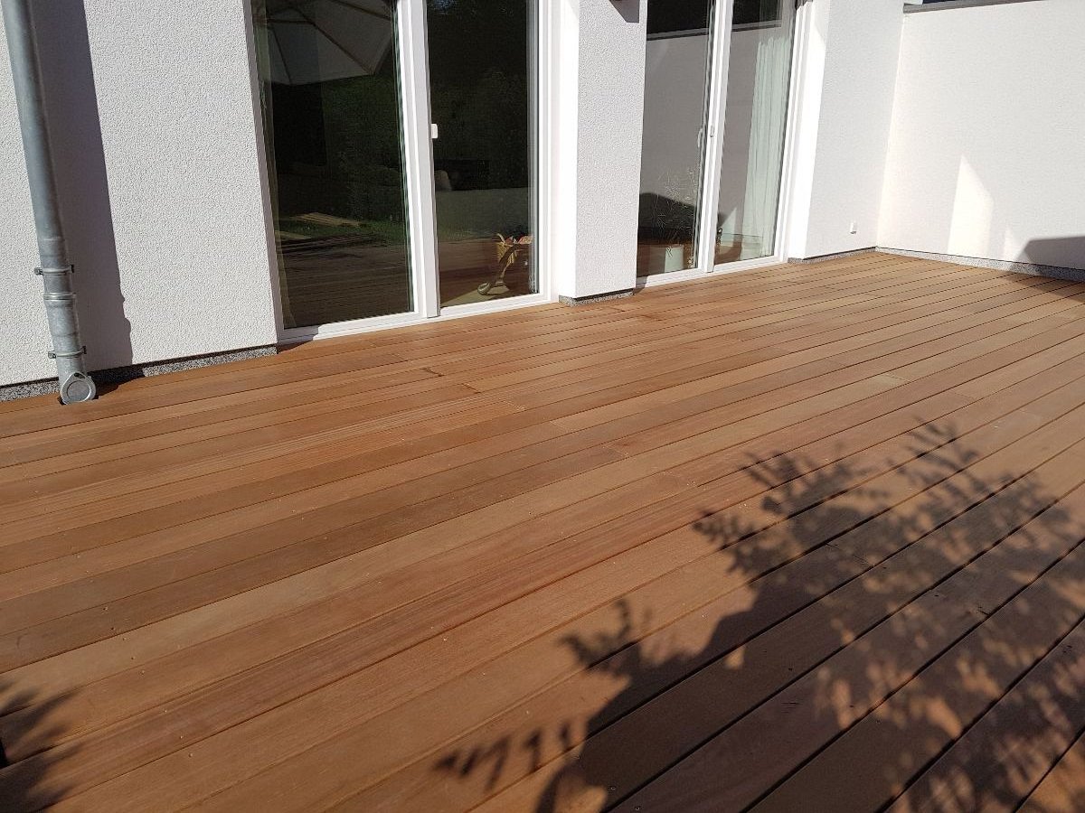 Neu verlegte Holzterrasse aus Hartholzdielen an einem Wohnhaus