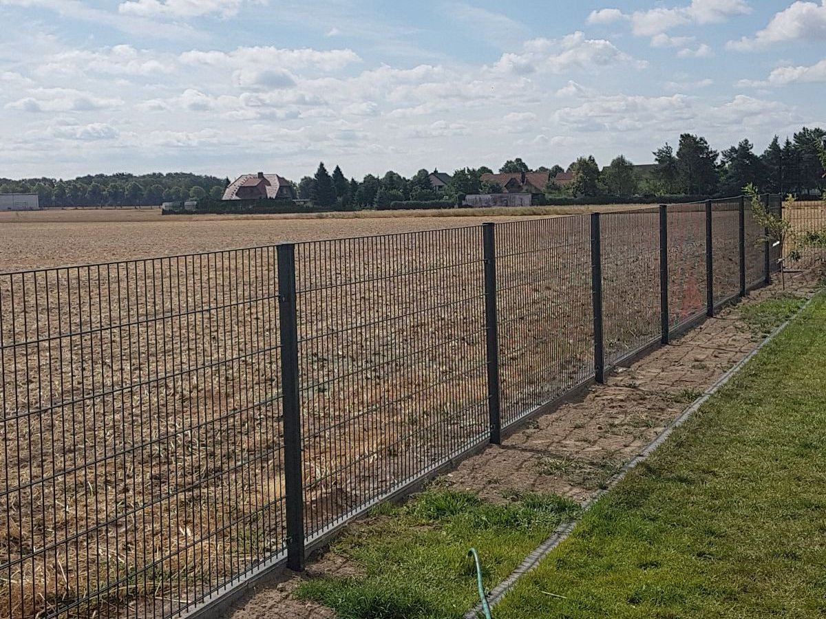 Neuer Doppelstabzaun entlang einer Grundstücksgrenze am Feldrand